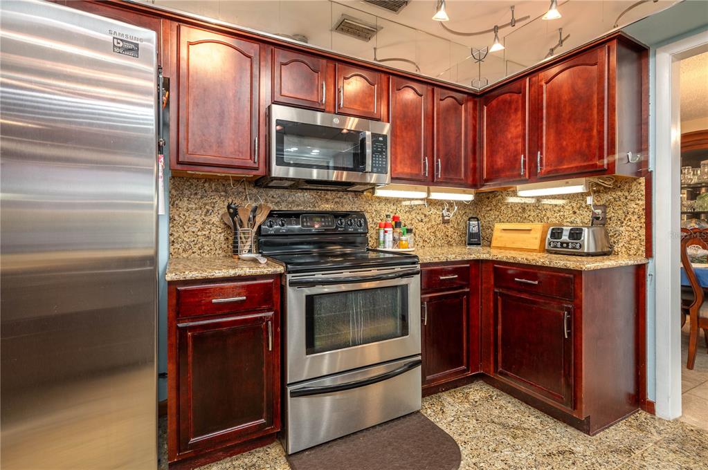 305 Hernando Road Winter Haven, FL 33884 - Photo 12 of 32 a kitchen with stainless steel appliances granite countertop a stove microwave and sink