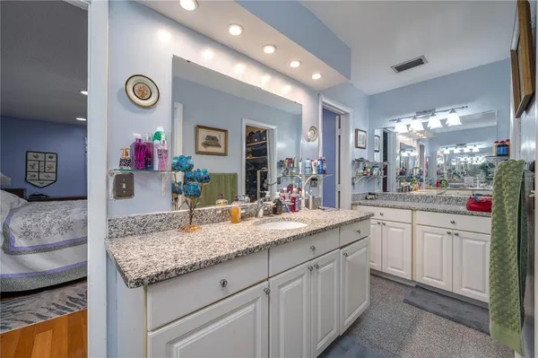 a bathroom with a granite countertop sink and a mirror