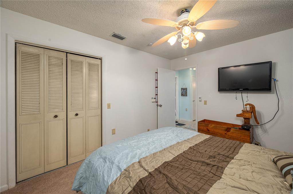 305 Hernando Road Winter Haven, FL 33884 - Photo 27 of 32 a bedroom with bed tv and a chandelier