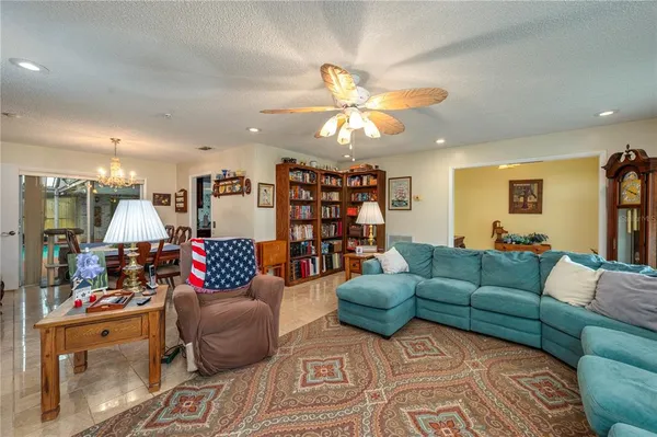 a living room with furniture kitchen and a chandelier