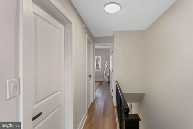 a view of a hallway with wooden floor and stairs