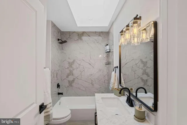 a bathroom with a sink and mirror with toilet