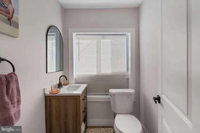 a bathroom with a toilet sink and mirror