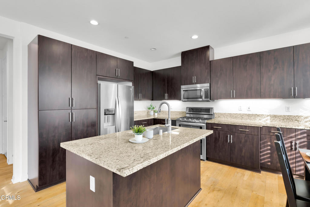 900 North Primrose Lane, Unit A Azusa, CA 91702 - Photo 13 of 55 a kitchen with granite countertop stainless steel appliances a refrigerator a stove a sink cabinets and a center island