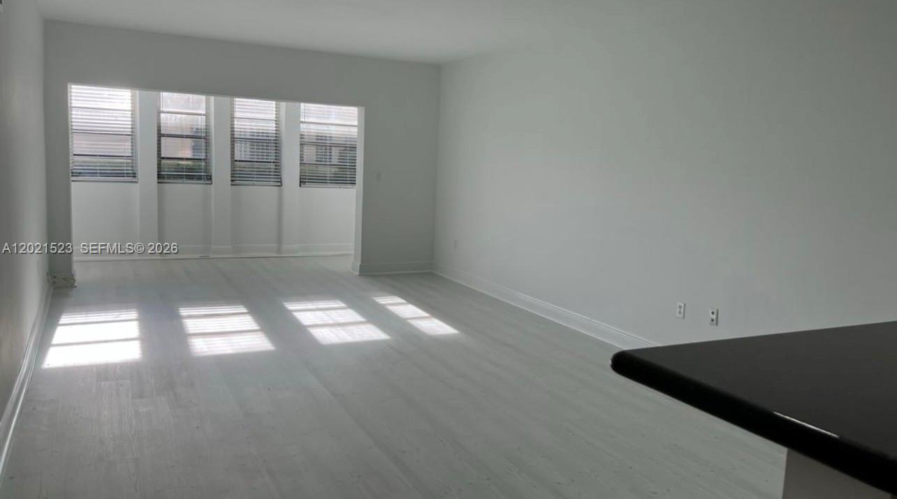 9159 Southwest 77th Avenue, Unit 101 Miami, FL 33156 - Photo 2 of 12 an empty room with windows