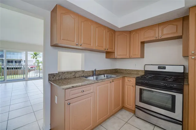 a kitchen with granite countertop a stove sink and cabinets