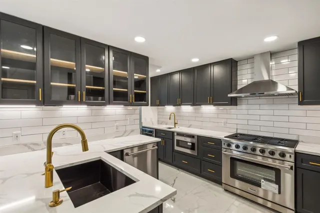 a kitchen with stainless steel appliances a stove and a sink
