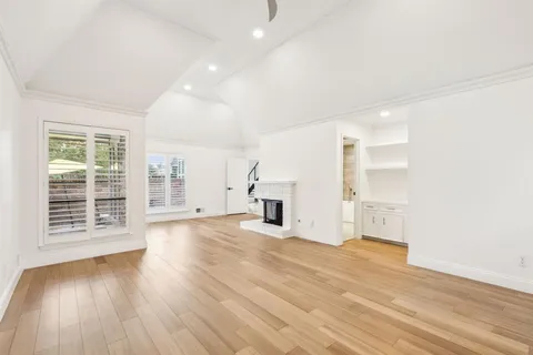 a view of empty room with wooden floor and fireplace
