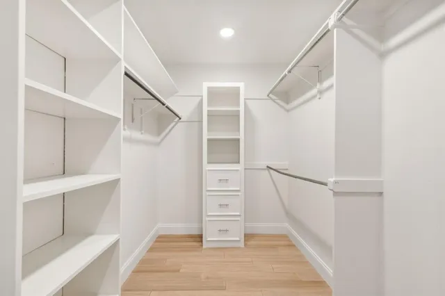 a view of walk in closet with empty racks