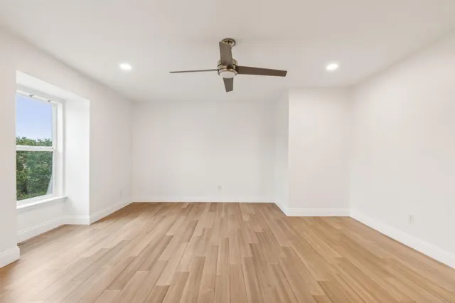 a view of a room with wooden floor and windows