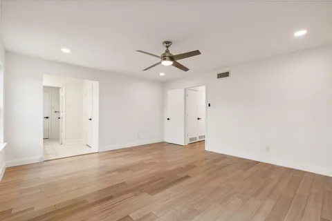 wooden floor in an empty room with a ceiling fan
