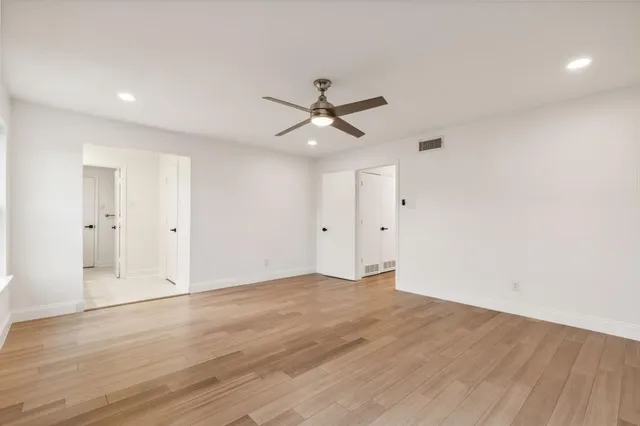 wooden floor in an empty room with a ceiling fan
