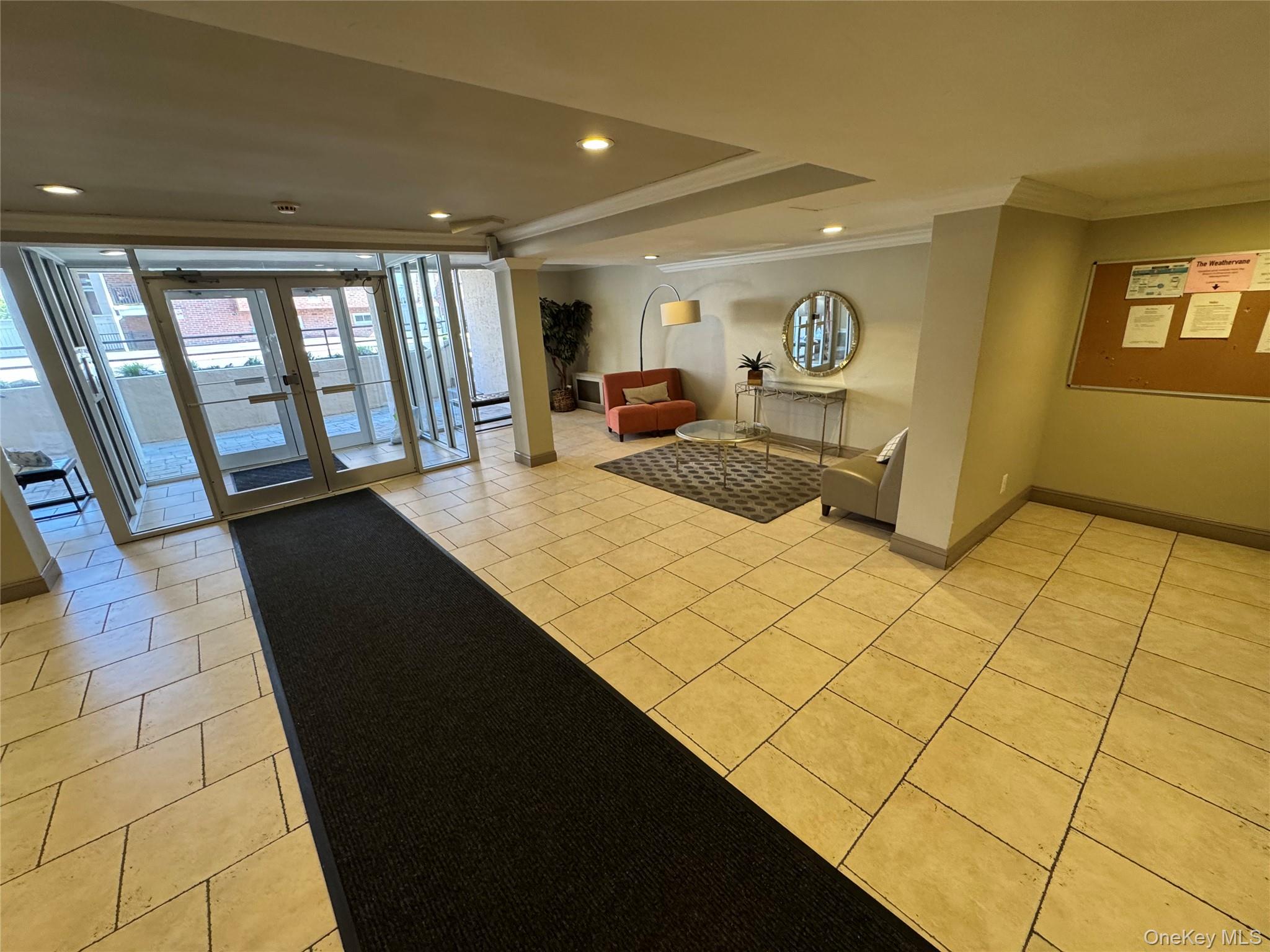 750 Shore Road, Unit 4N Long Beach, NY 11561 - Photo 4 of 14 a living room with a black white checkered floor with kitchen view and wooden floor