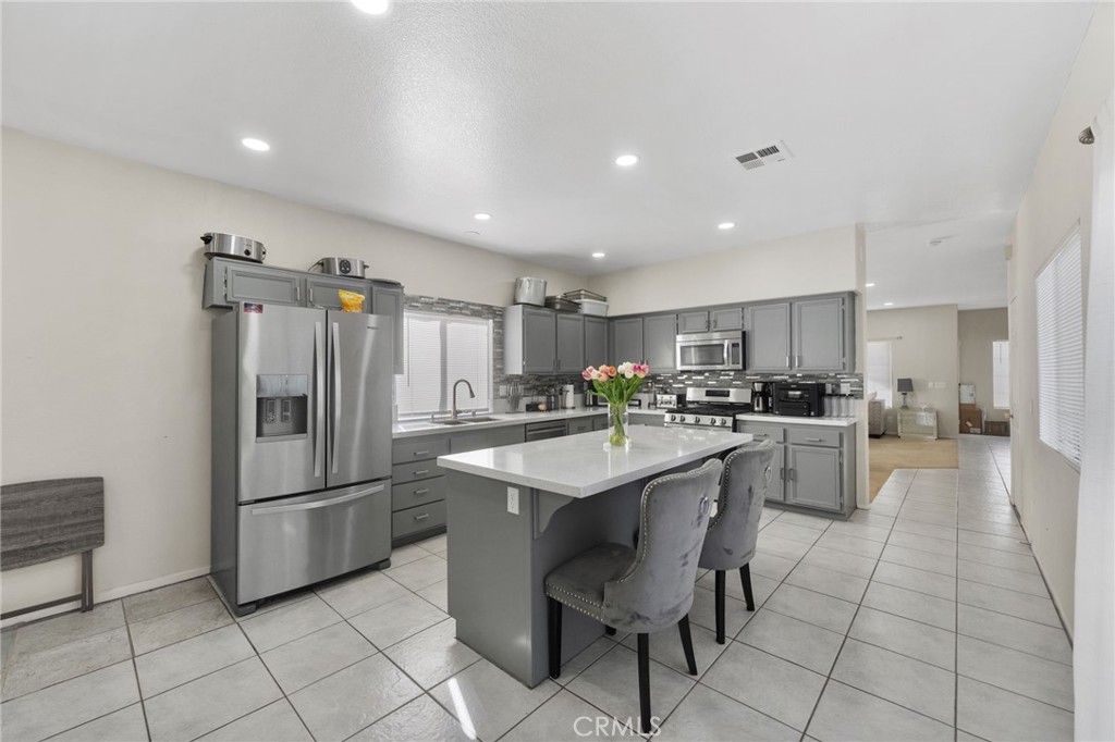 1494 Rabbit Peak Way Hemet, CA 92545 - Photo 17 of 45 a kitchen with stainless steel appliances a sink a stove a refrigerator and cabinets