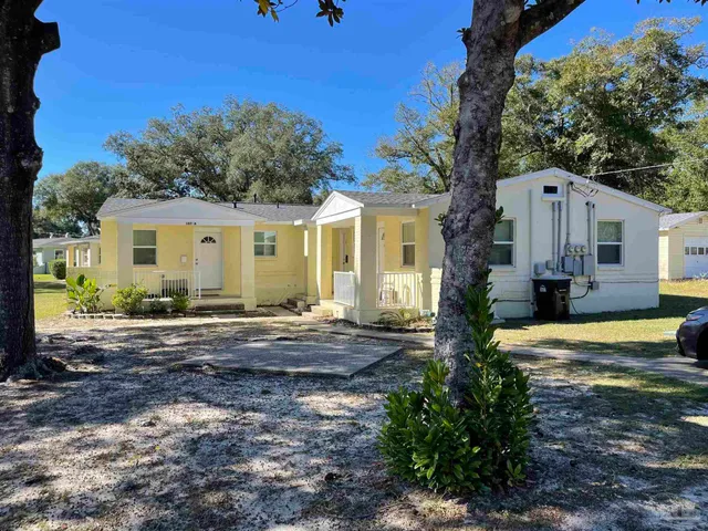 a view of a house with backyard and trees