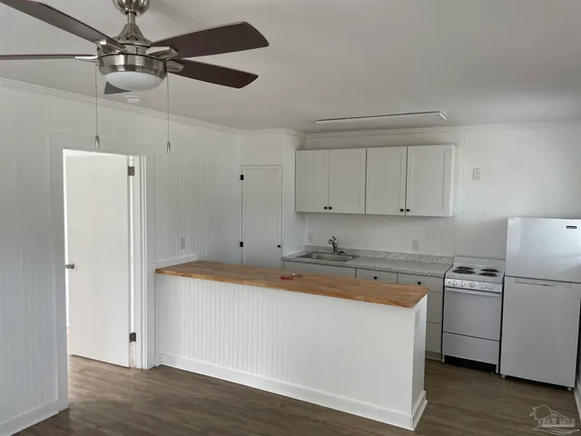 a kitchen with a sink a stove a refrigerator and cabinets
