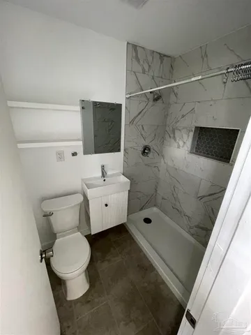a bathroom with a toilet sink and shower