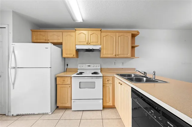 a kitchen with a stove a refrigerator and white cabinets