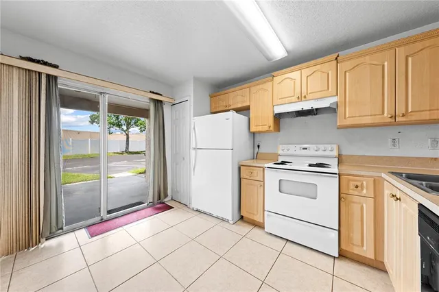 a view of a kitchen with white cabinets and stainless steel appliances
