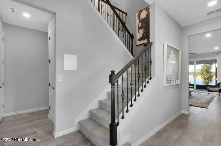 677 Blind Oak Cir Street St. Augustine, FL 32095 - Photo 16 of 19 a view of staircase with lots of frames and a rug