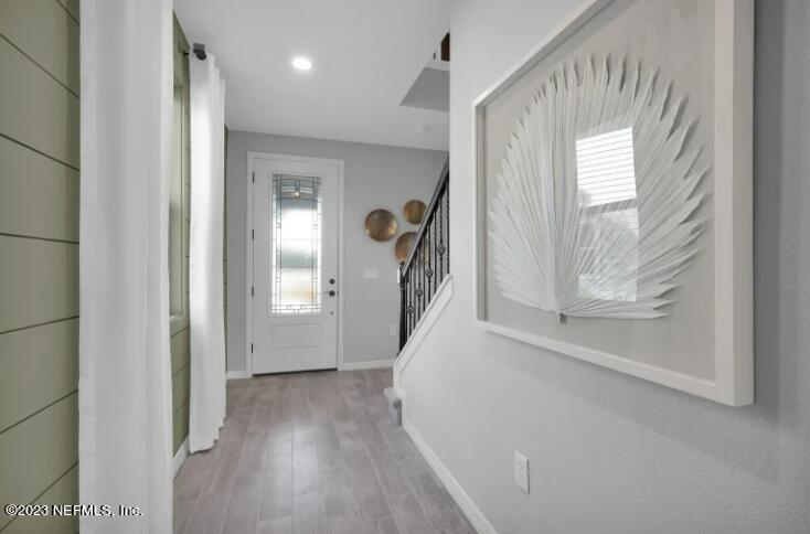 677 Blind Oak Cir Street St. Augustine, FL 32095 - Photo 17 of 19 a view of a hallway to a livingroom with wooden floor and stairs
