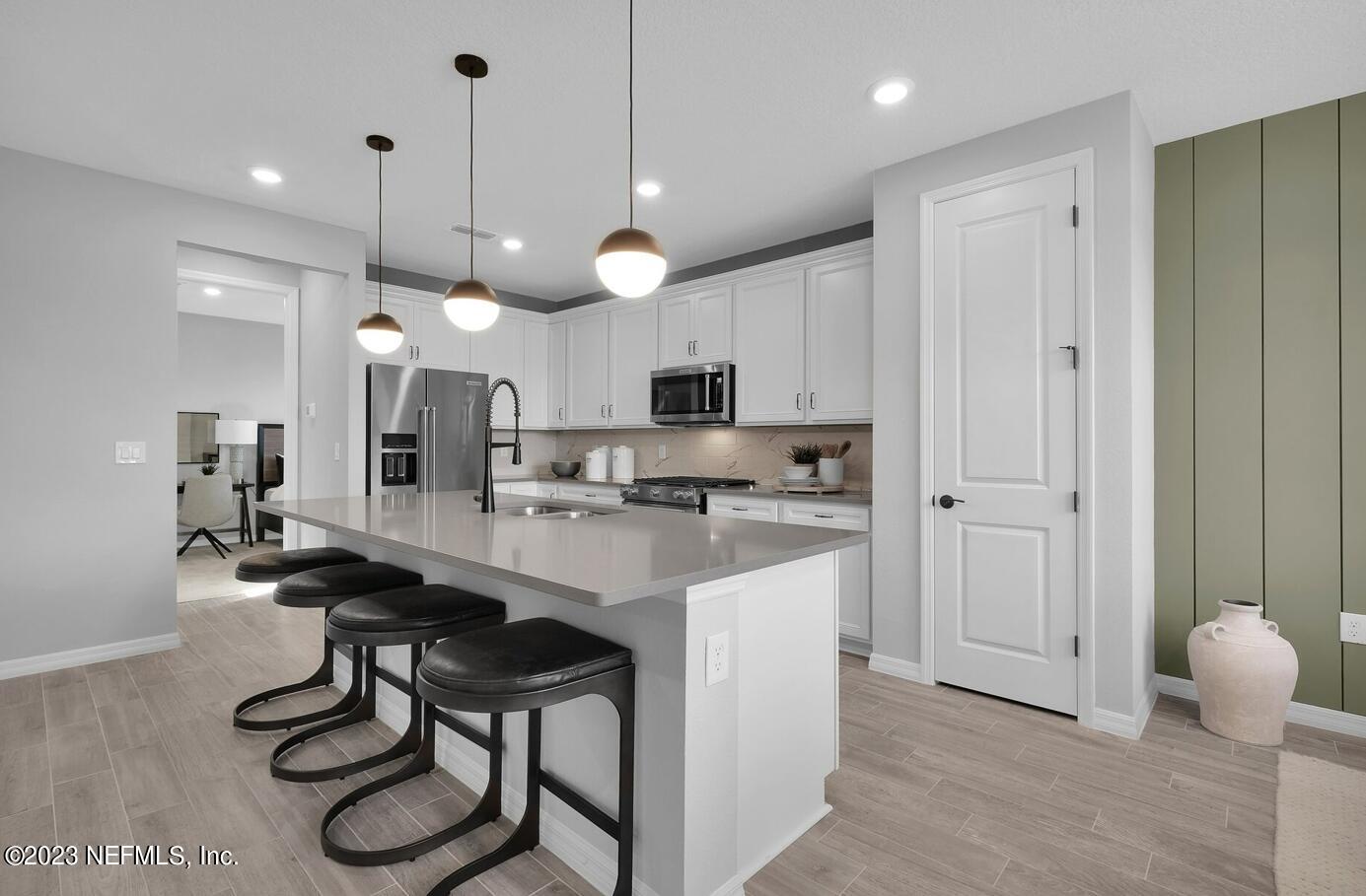 677 Blind Oak Cir Street St. Augustine, FL 32095 - Photo 2 of 19 a kitchen with kitchen island a dining table chairs and a sink