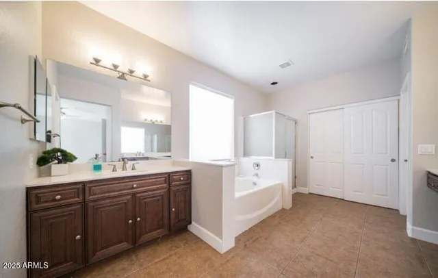 a large bathroom with a sink mirror and a bathtub