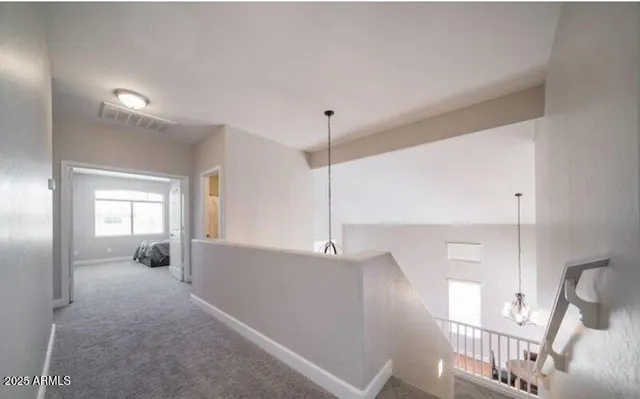 a view of a hallway with wooden floor and windows