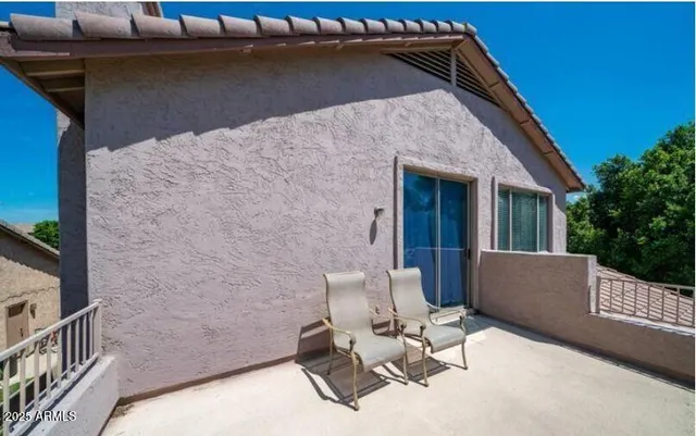 a view of backyard with chair and white wall