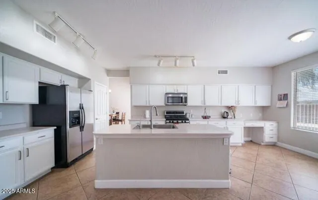 a kitchen with stainless steel appliances a refrigerator sink stove microwave and cabinets