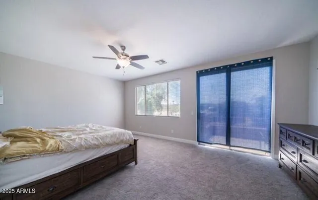a bedroom with a bed and a ceiling fan