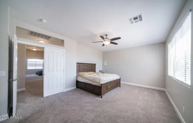 a spacious bedroom with a bed and a chandelier