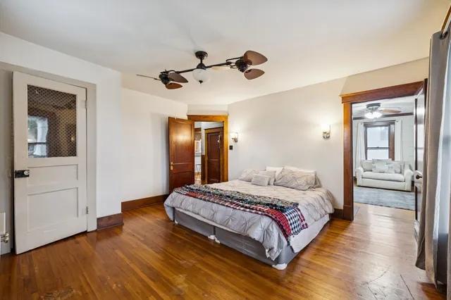 a bedroom with a bed and wooden floor
