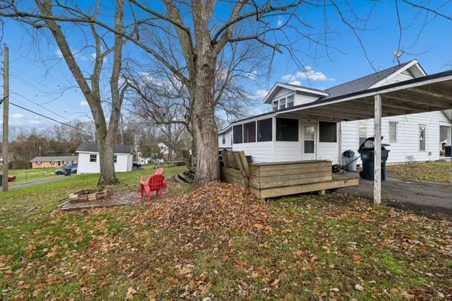 a view of a house with a large tree and a wooden fence
