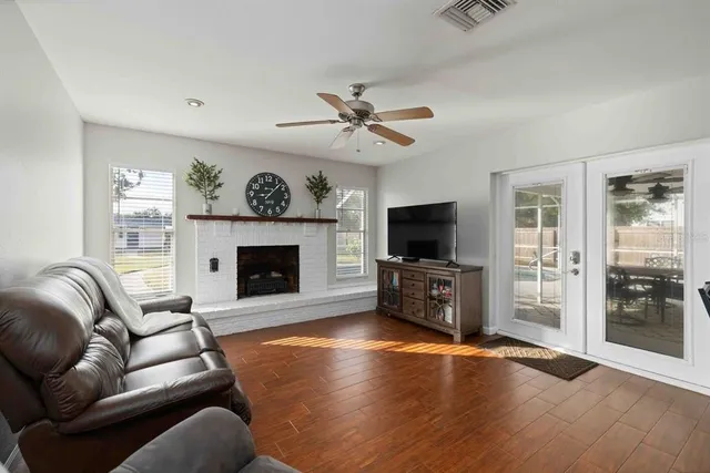 a open kitchen with stainless steel appliances granite countertop a refrigerator a stove and a dining table with wooden floor