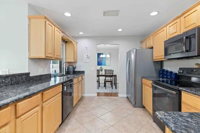 a large kitchen with stainless steel appliances granite countertop a sink and cabinets