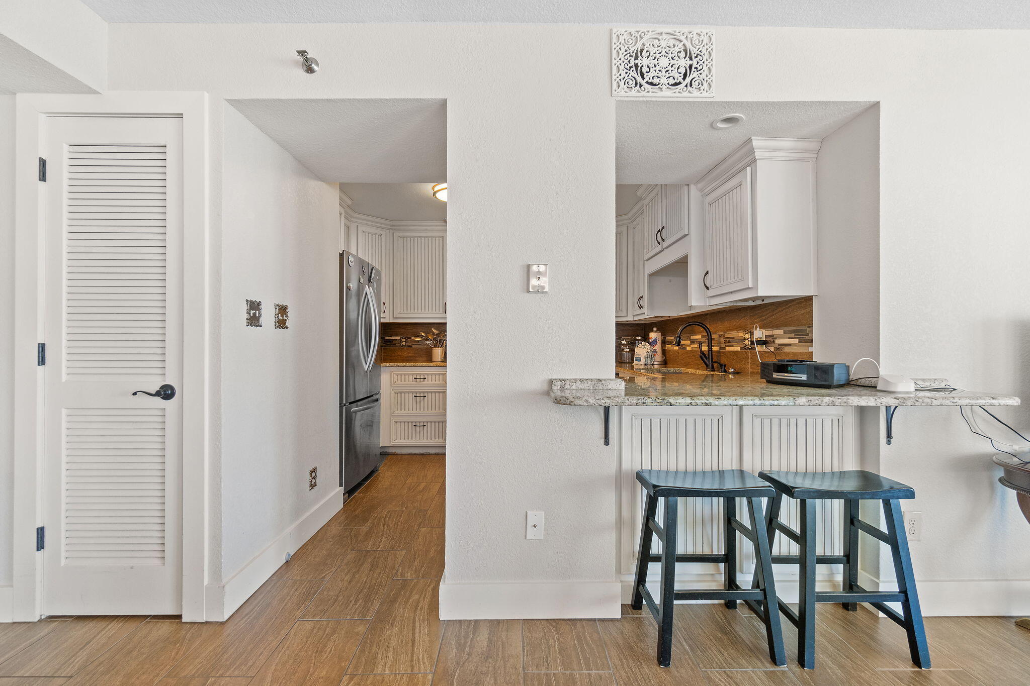 1200 Fort Pickens Road, Unit 1E Pensacola Beach, FL 32561 - Photo 17 of 44 a kitchen with stainless steel appliances granite countertop a refrigerator and a stove top oven