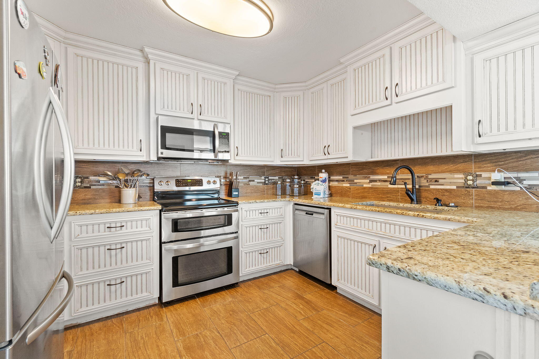 1200 Fort Pickens Road, Unit 1E Pensacola Beach, FL 32561 - Photo 18 of 44 a kitchen with stainless steel appliances granite countertop a stove a sink and a refrigerator