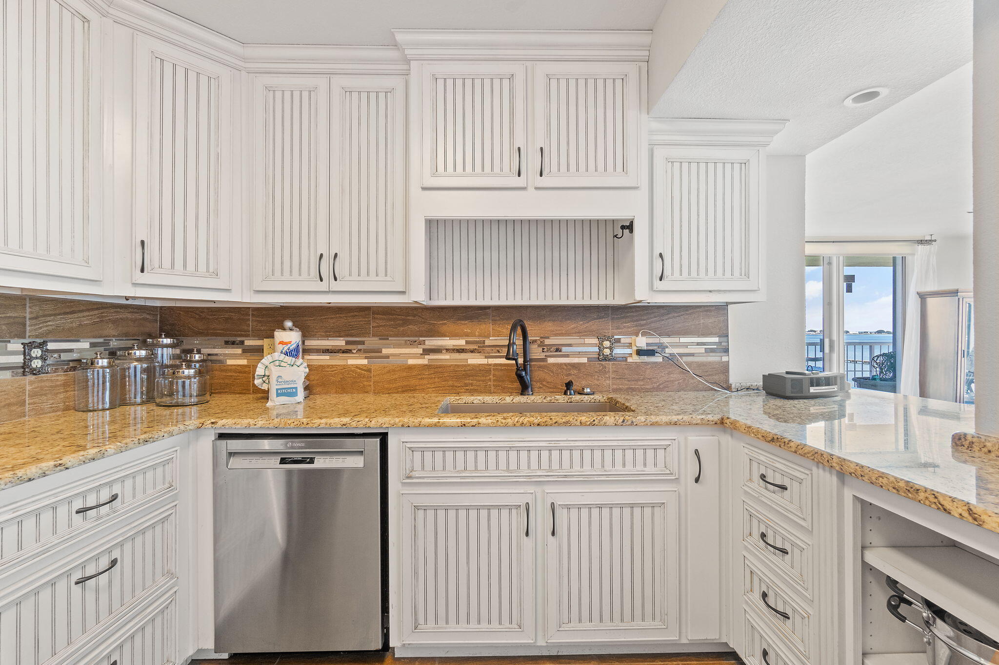 1200 Fort Pickens Road, Unit 1E Pensacola Beach, FL 32561 - Photo 19 of 44 a kitchen with granite countertop a sink stove and cabinets