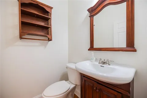 a bathroom with a sink a toilet and mirror