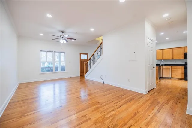 a view of an empty room with window and wooden floor