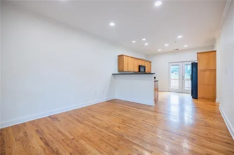 a view of a big room with wooden floor and a kitchen