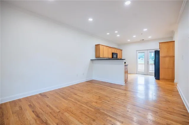 a view of a big room with wooden floor and a kitchen