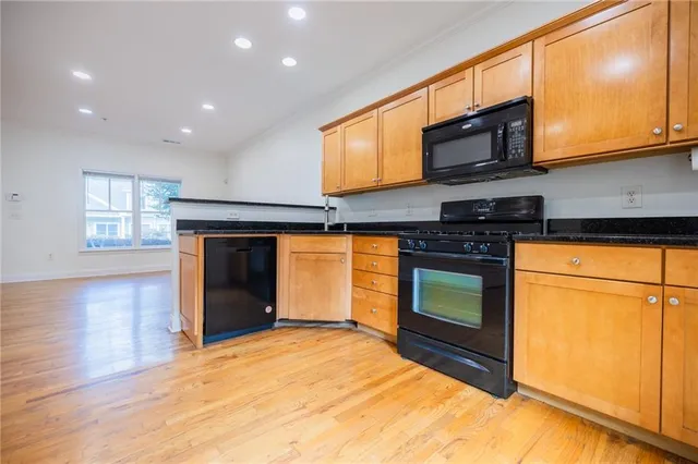 a kitchen with stainless steel appliances granite countertop a stove top oven a sink and a microwave