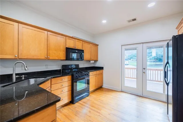 a kitchen with stainless steel appliances granite countertop a stove a sink and a microwave