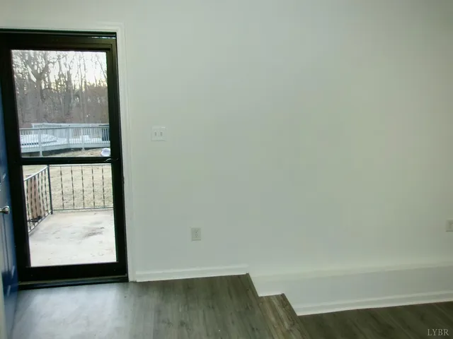 a view of a room with wooden floor and a window