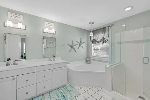 a bathroom with a double vanity sink mirror and bathtub