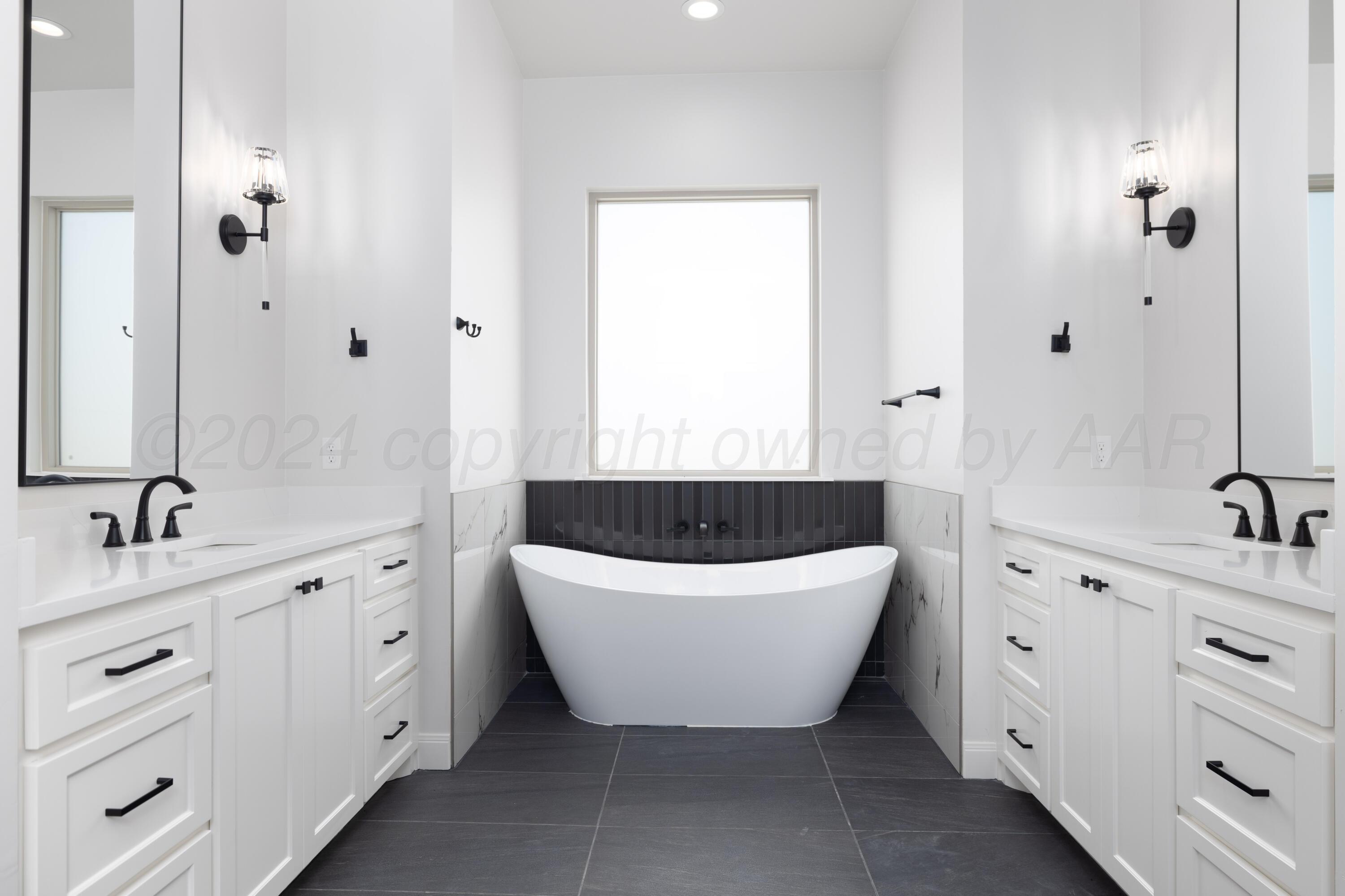 10150 Cactus Flower Road Amarillo, TX 79119 - Photo 24 of 47 a spacious bathroom with a bathtub sink and mirror