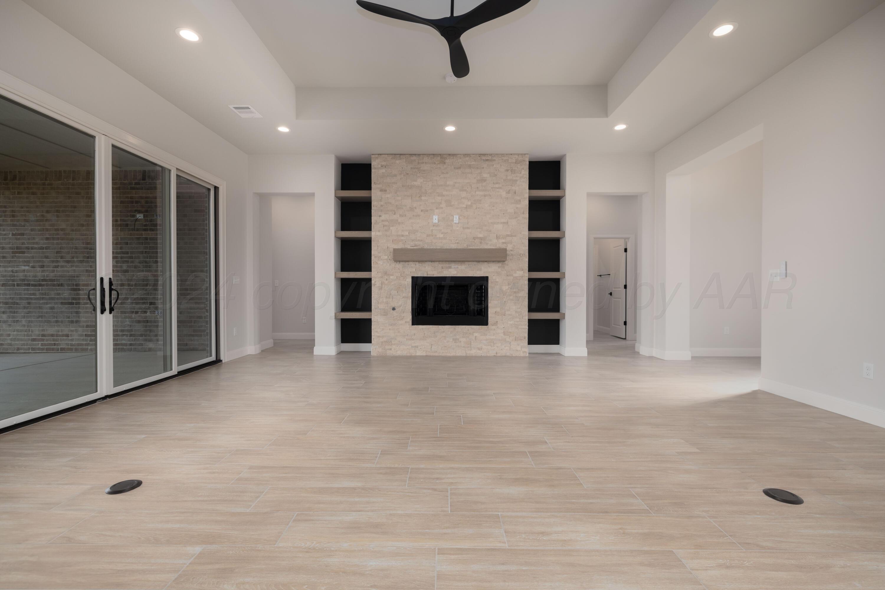 10150 Cactus Flower Road Amarillo, TX 79119 - Photo 5 of 47 an empty room with fireplace and cabinet