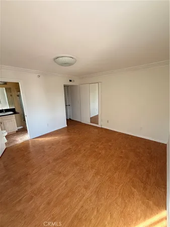 a view of an empty room with closet and a window